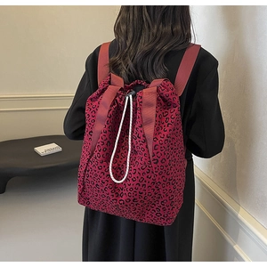 Detail of red leopard print drawstring backpack on model showing size and texture
