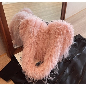 Gros plan d'un sac cabas rose en fausse fourrure douce sur fond noir texturé