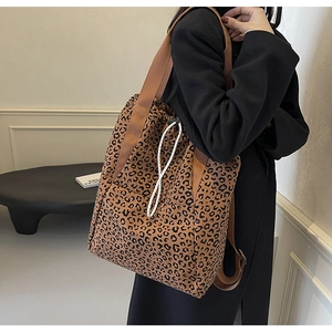 Detail of leopard print tote bag with white drawstring closure and wide brown strap