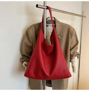 Close-up of red pebbled leather tote bag with minimalist hobo design and large capacity