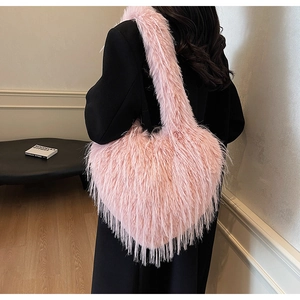 Détail d'un sac à épaule rose en fausse fourrure en forme de cœur sur un manteau noir