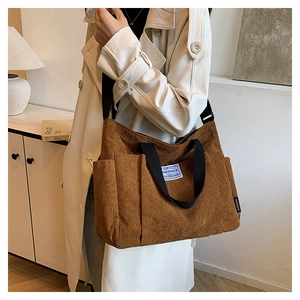 Close-up of brown corduroy tote bag featuring vertical ribbed texture and side pocket