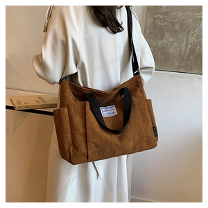 Brown corduroy tote bag showing large capacity, side pockets and adjustable strap detail