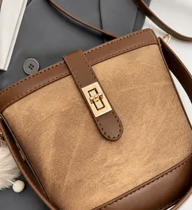 Close-up of vintage brown twill bucket bag with premium gold metallic turn-lock closure