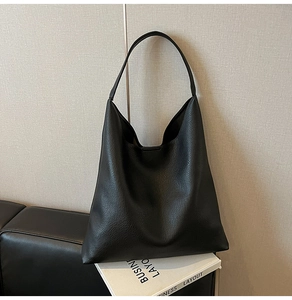 Detail of premium black lychee texture leather on a large capacity hobo tote bag