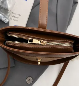 Detail of smooth metal zipper and premium two-tone leather texture on brown bucket bag