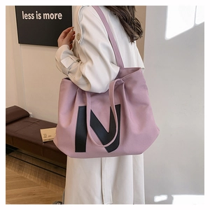 Pink canvas tote bag with large black letter N detail and spacious interior for daily use