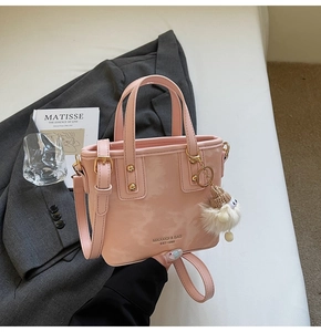 Detail der rosafarbenen Lackleder-Eimertasche mit Plüsch-Anhänger und Schultergurt