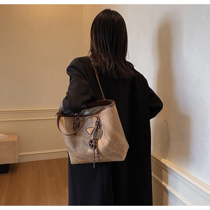 Vue détaillée du sac cabas rétro marron avec logo triangulaire et bandoulière fine