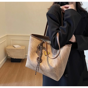 Détail du grand sac cabas vintage marron avec breloque tissée et patch décoratif jaune