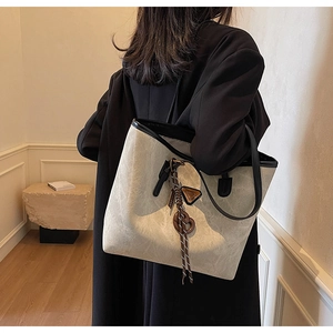 Détail d'un grand sac cabas gris avec texture marbre et anses noires sur l'épaule