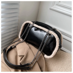 Detail of cylinder crossbody bag featuring shiny black leather and faux shearling trim