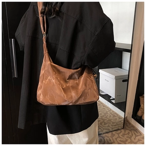 Close-up of brown nylon shoulder bag with silk sheen and adjustable wide strap