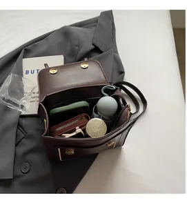 Top view of spacious interior of brown retro crossbody bag holding daily essentials