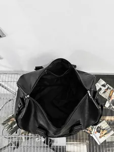 Vue intérieure montrant la grande capacité du sac de voyage en simili cuir noir