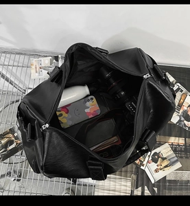 Vue de dessus d'un grand sac de voyage en similicuir noir montrant sa grande capacité interne