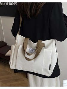 Large white corduroy tote bag for women shown from a side view with shoulder strap