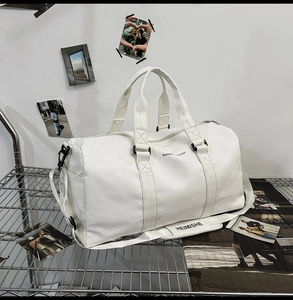 Détail du sac de voyage en cuir blanc avec poignées renforcées et bandoulière réglable