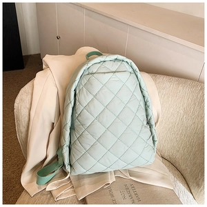Détail du sac à dos en nylon vert menthe matelassé avec texture à losanges doux