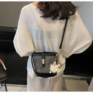 Retro color-block bucket bag with plush charm shown from a back perspective view