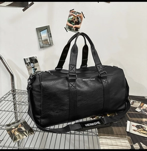 Détail du sac de voyage en cuir PU noir avec surface texturée et bandoulière réglable