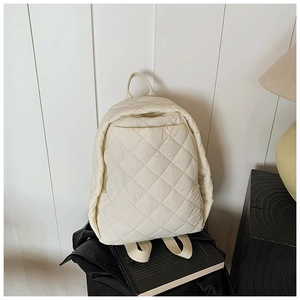 Détail du sac à dos blanc crème avec motif matelassé losange et fermeture éclair