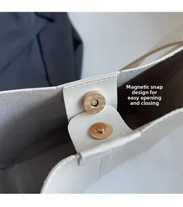 Close-up of secure magnetic snap closure on cream leather tote bag with soft lining