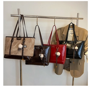 Série de grands sacs cabas en similicuir en diverses couleurs avec des breloques