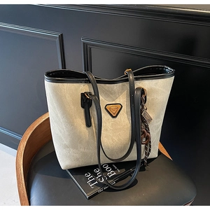Détail du sac cabas gris mat avec bandoulières contrastées noires et logo triangulaire