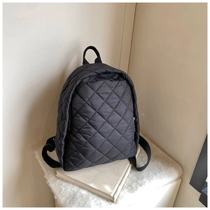 Détail du sac à dos matelassé noir en nylon avec texture classique à losanges brodés