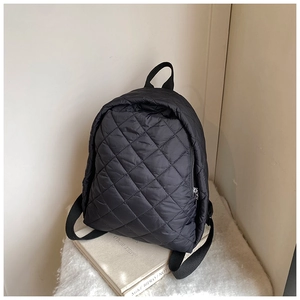 Détail du motif matelassé en losange et de la fermeture éclair métallique du sac à dos