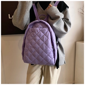 Détail du sac à dos matelassé violet montrant la texture douce des losanges