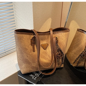 Vue détaillée du sac cabas rétro marron avec logo triangle en métal et texture cuir