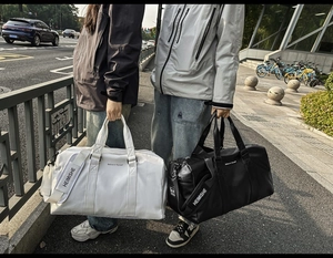 Détail de sacs de voyage grande capacité en noir et blanc avec bandoulière réglable