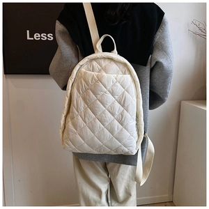 Vue détaillée du sac à dos matelassé blanc avec coutures en losanges et bretelles
