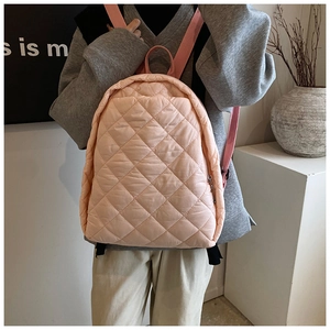 Gros plan du sac à dos rose matelassé avec motif à losanges et bretelles réglables
