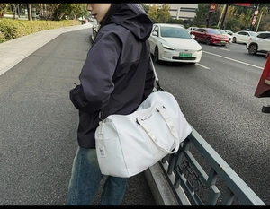Vue détaillée du sac de voyage blanc avec bandoulière et slogan de motivation