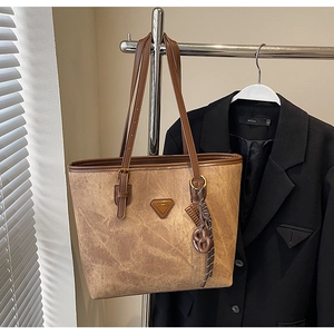 Détail du sac cabas vintage marron avec plaque en métal et texture tressée