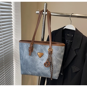 Détail du sac cabas rétro en toile délavée avec lanières en cuir et décor en métal