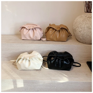 Détail de sacs nuages plissés en rose, marron, beige et noir sur des marches