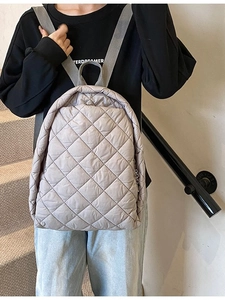 Sac à dos taupe clair à motif losanges matelassé porté par un mannequin pour voyage