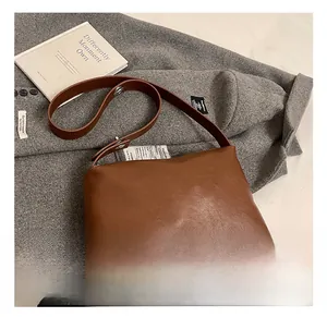 Détail de la texture en similicuir marron et du design minimaliste de ce sac à bandoulière