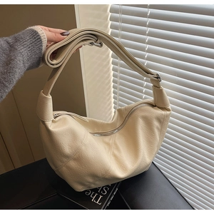 Dettaglio della trama in ecopelle beige e della cerniera argentata della borsa hobo