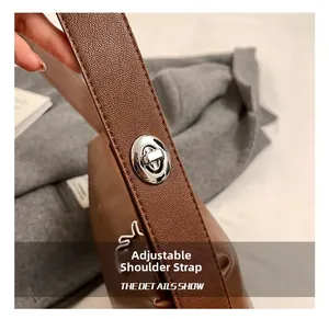 Gros plan sur la bandoulière réglable du sac Boston en cuir vintage marron avec boucle