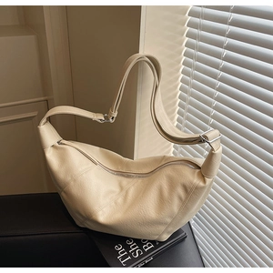 Close-up of beige lychee grain leather underarm bag with zipper and silver buckle