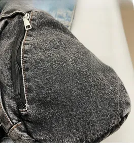 Macro detail of washed denim fabric with a black zipper and silver metal puller