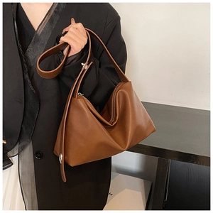 Détail du sac à épaule en cuir marron caramel avec design plié minimaliste et fermeture