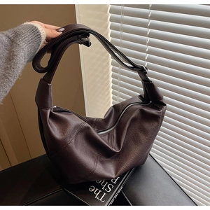 Dettaglio borsa hobo in ecopelle marrone scuro con cerniera argentata e tracolla