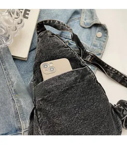 Close-up of the washed denim crossbody bag featuring a secure back zipper pocket for phones