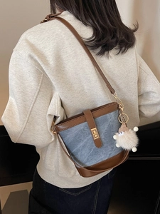 Blue denim bucket bag with brown leather trim and a cute plush sheep pendant charm